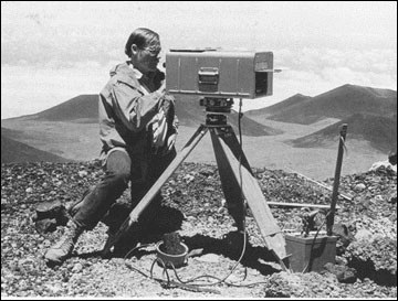 Black and white image of a person using a geodimeter